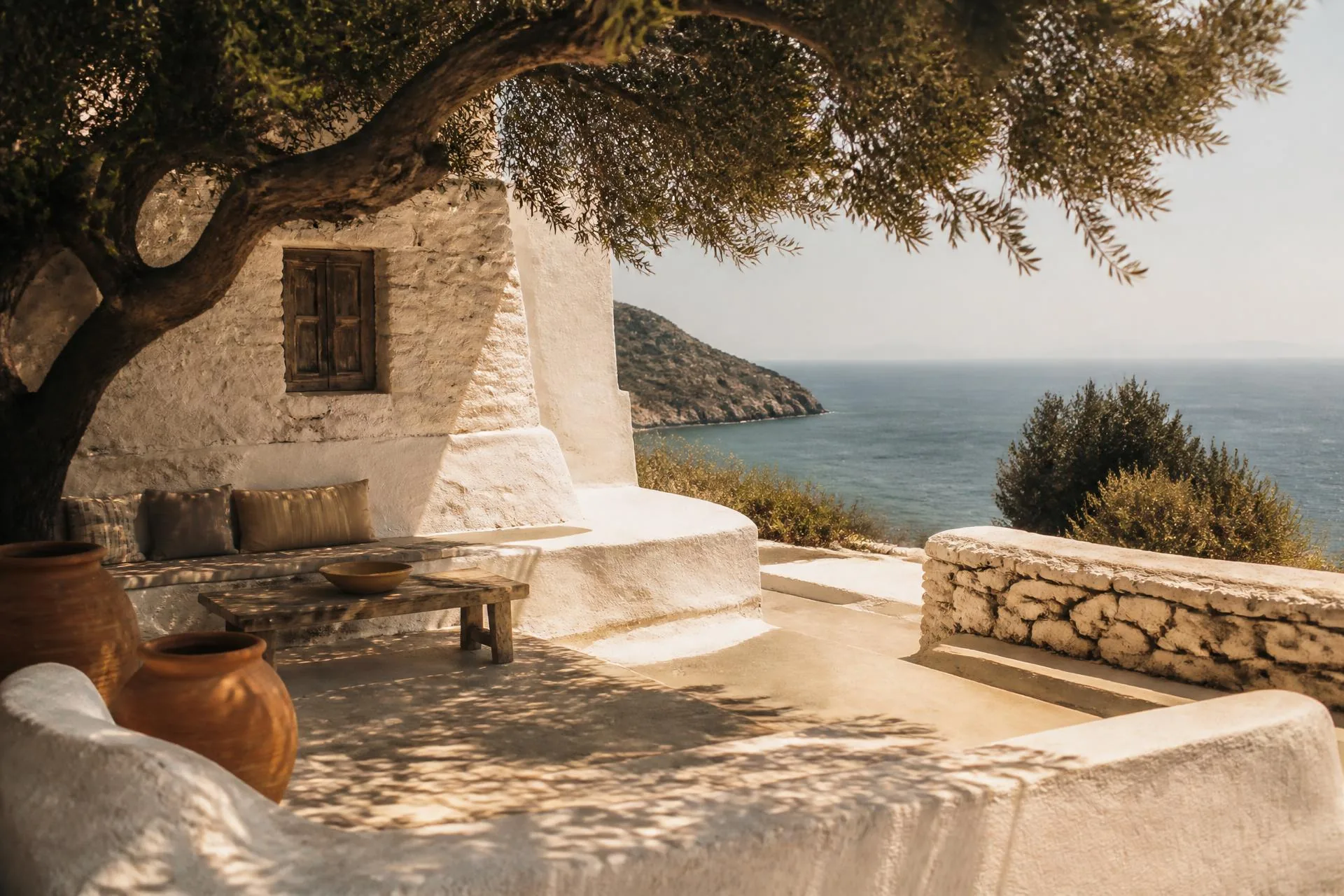 Sunlight on the Mediterranean sea seen from a shaded seaside terrace at midday.